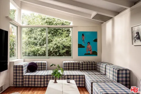 a view of a balcony with furniture and floor to ceiling window