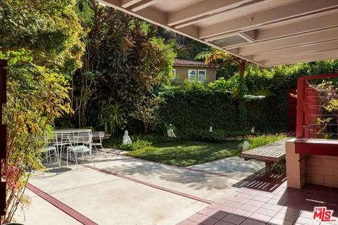a view of a patio with a table and chairs under an umbrella