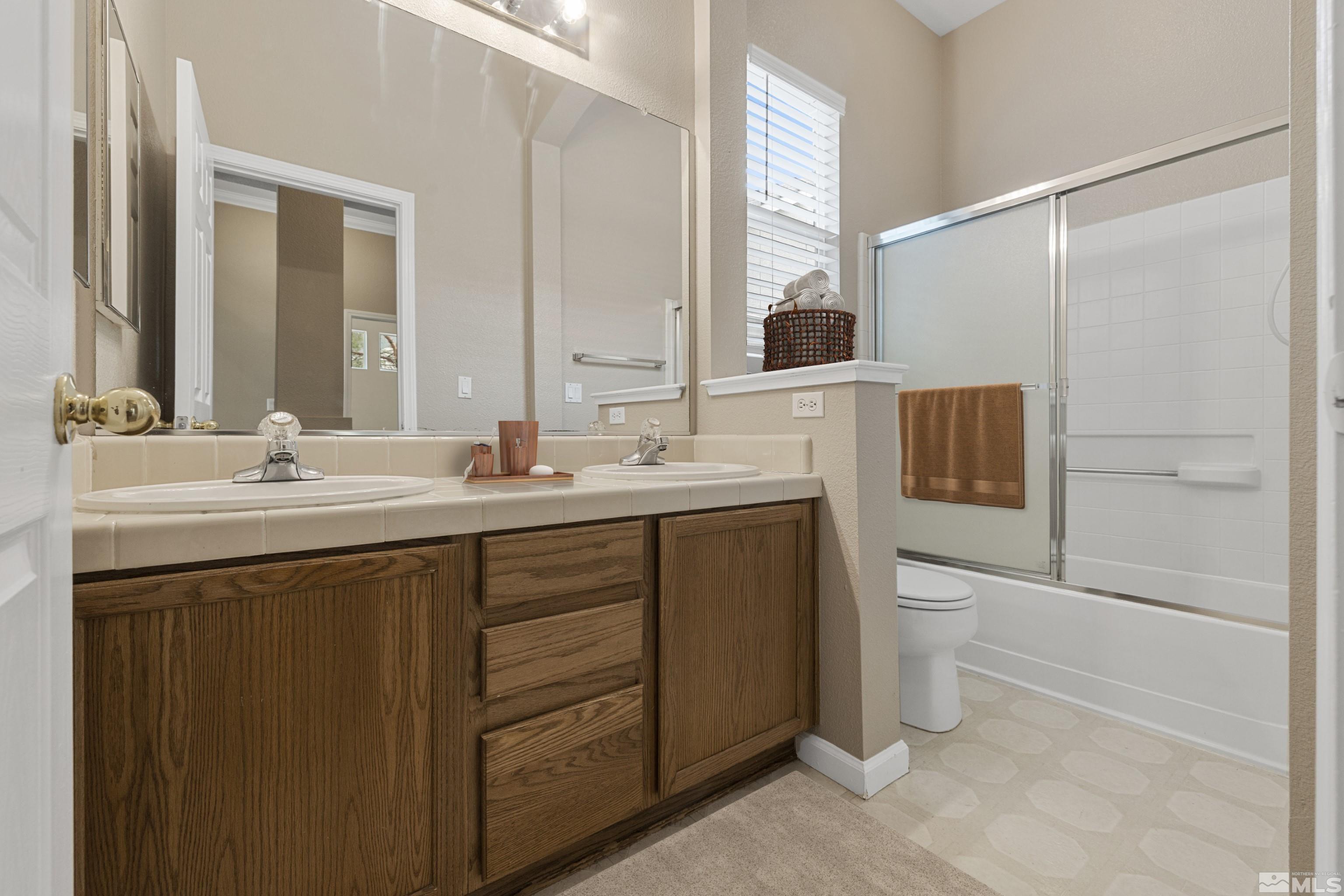 10280 Wolf Ridge Way Reno, NV 89521 - Photo 7 of 19 a bathroom with a double vanity sink toilet and mirror