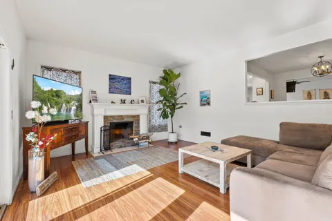 a kitchen with stainless steel appliances granite countertop a refrigerator a stove and a sink with wooden floor