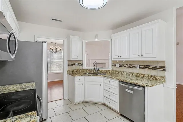 a kitchen with stainless steel appliances granite countertop a stove a sink and a refrigerator