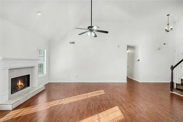 a view of empty room with wooden floor and fireplace