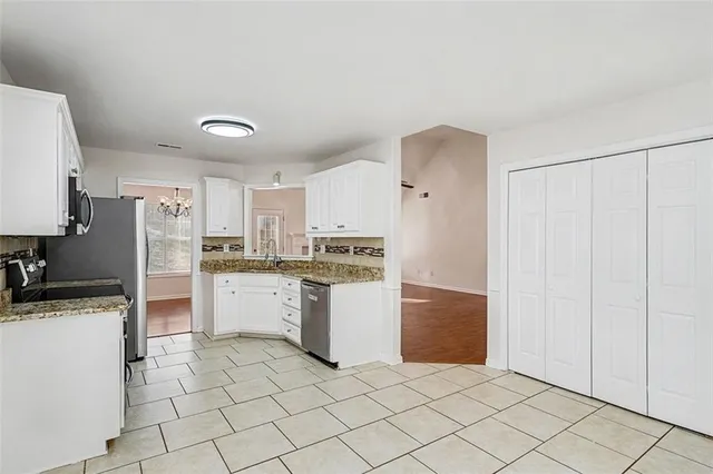 a kitchen with a refrigerator and white cabinets