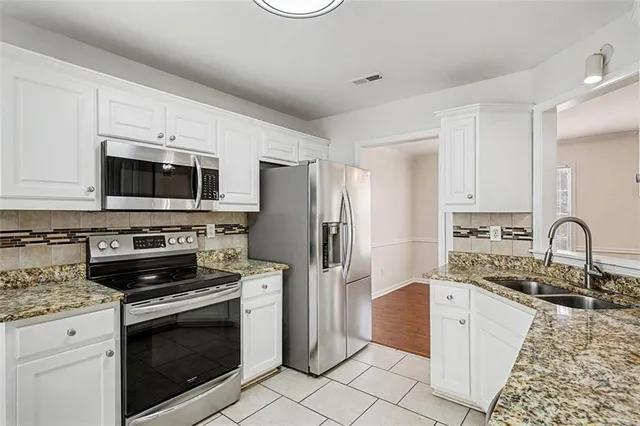 a kitchen with stainless steel appliances granite countertop a stove microwave and a sink