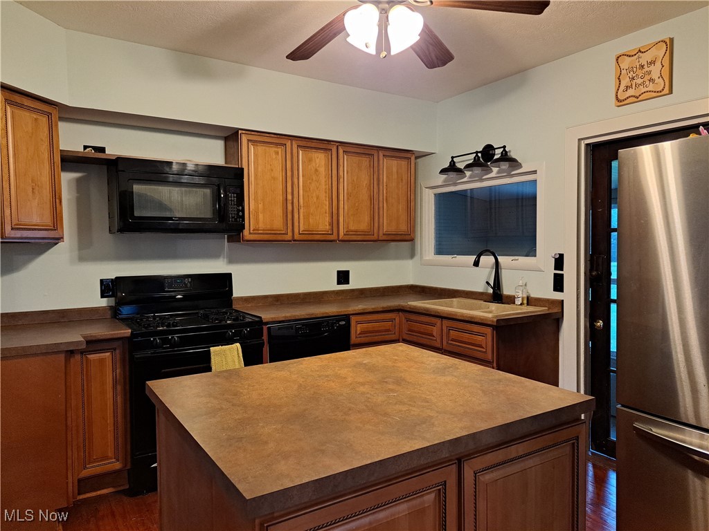 49197 John Tomcho Road Cumberland, OH 43732 - Photo 22 of 50 Kitchen featuring black appliances, sink, a kitchen island, dark wood-type flooring, and ceiling fan