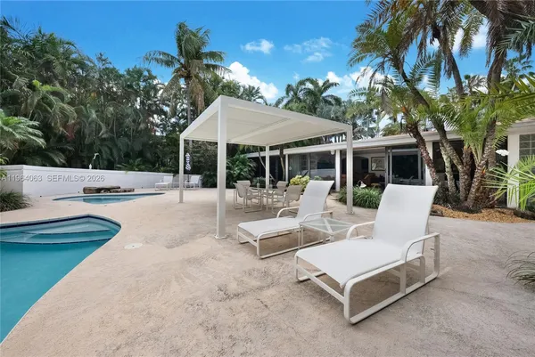 a view of a patio with a table and chairs under an umbrella