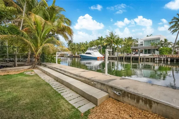 a view of a lake with a yard and large trees
