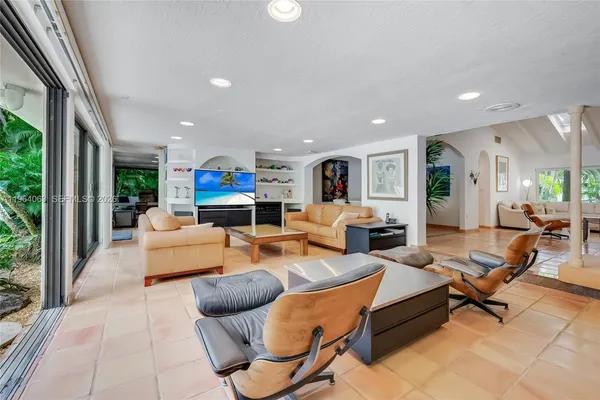 a living room with furniture kitchen view and a large window