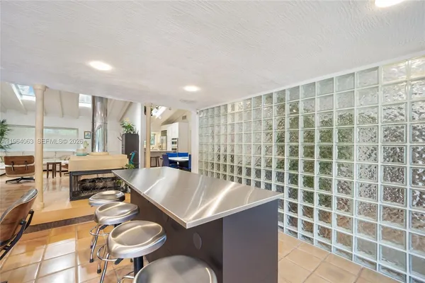 a large kitchen with a sink and chairs