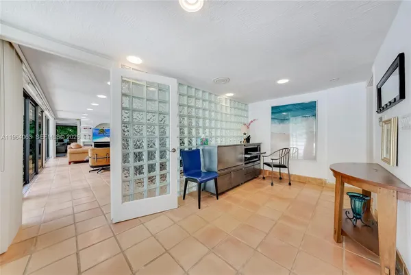 a living room with furniture and a dining table with projector the kitchen