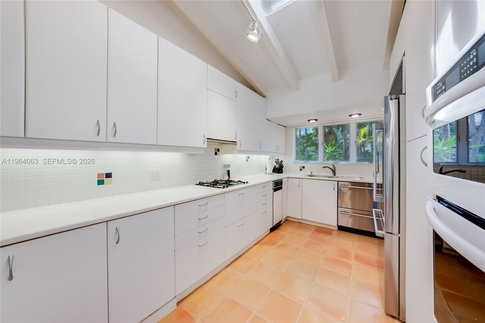 278 South Island Road Golden Beach, FL 33160 - Photo 28 of 57 a kitchen with cabinets a sink and white appliances