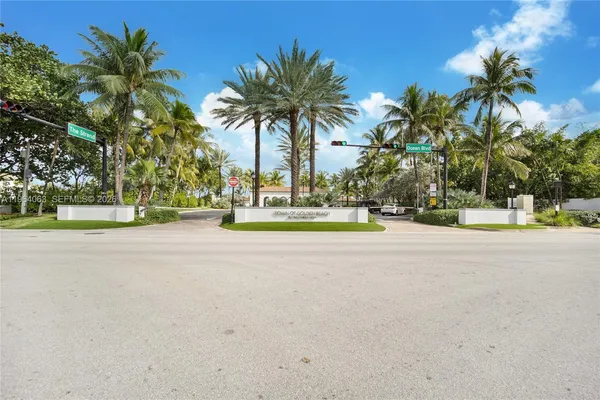 a view of a swimming pool with a lawn chairs under palm trees