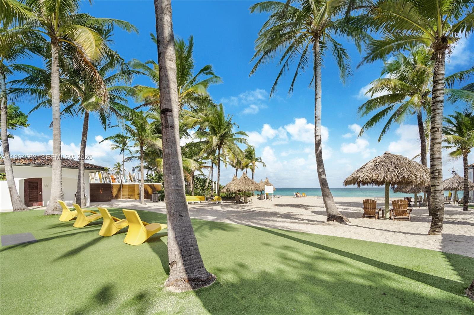 278 South Island Road Golden Beach, FL 33160 - Photo 51 of 57 a view of a swimming pool with a lawn chairs under palm trees