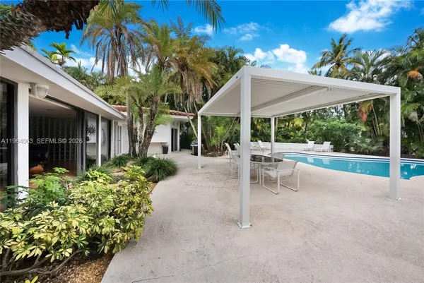 a view of a patio with a table and chairs under an umbrella
