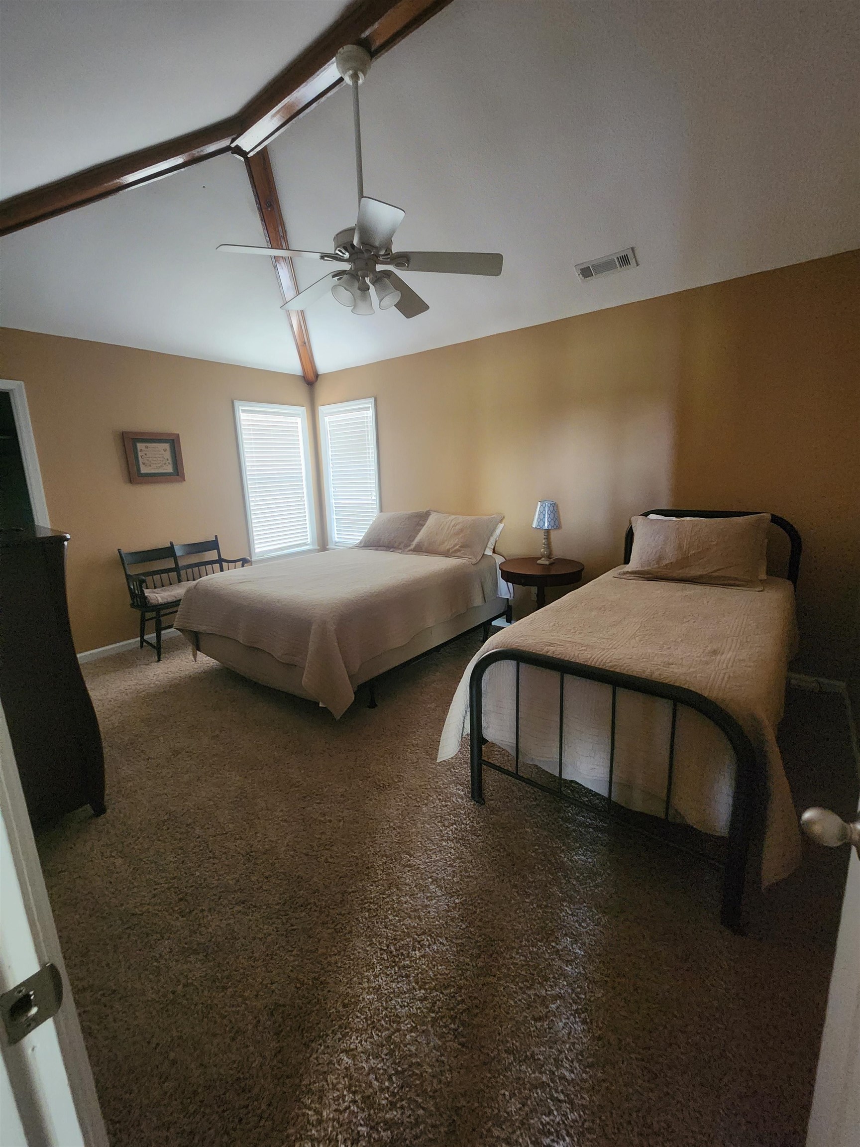 71 Chickasaw Trace Cherokee, AL 35616 - Photo 11 of 19 Spacious room featuring vaulted ceilings with exposed wood beams, two windows with blinds, a ceiling fan with integrated lighting, and carpeted flooring