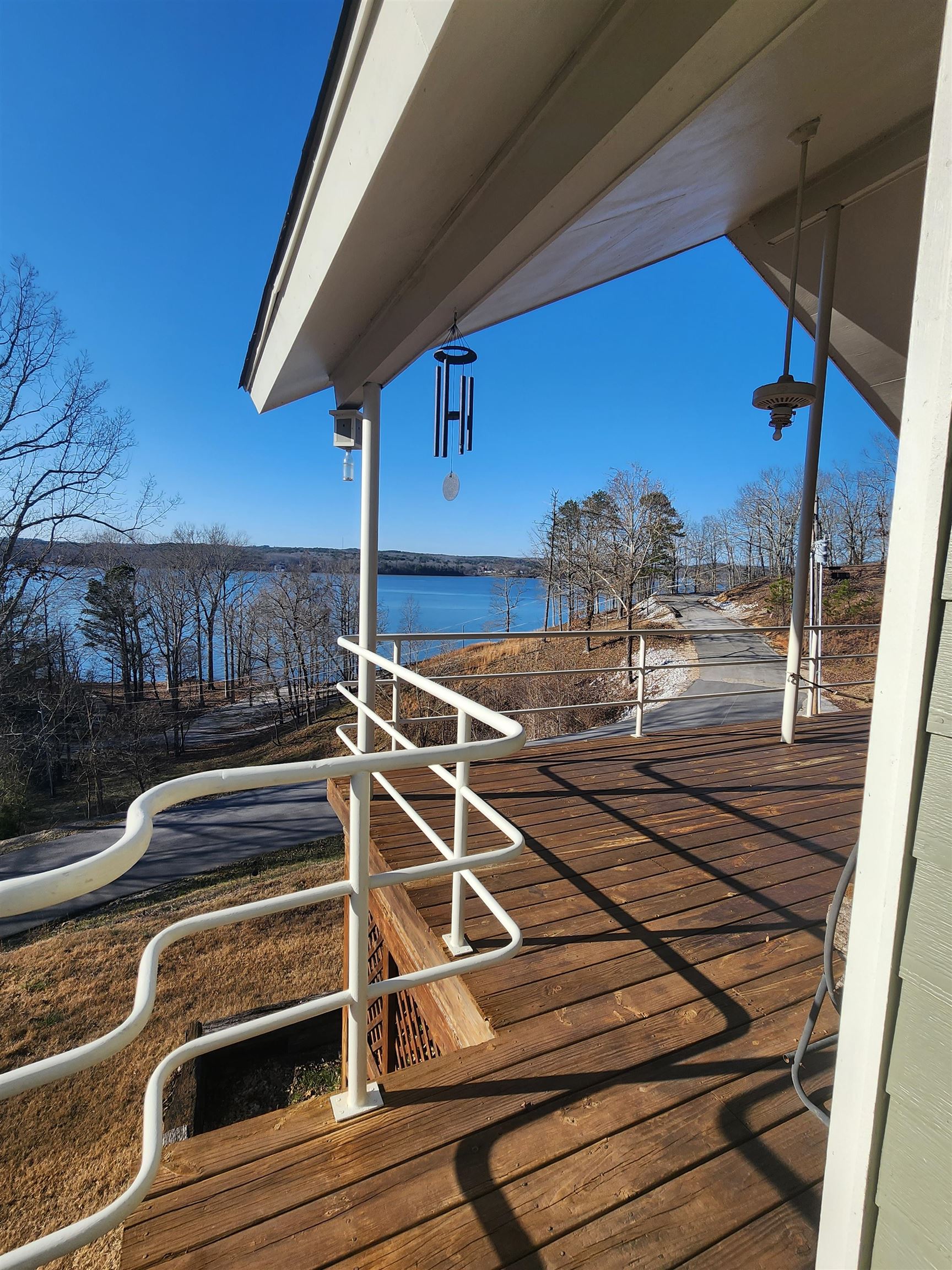 71 Chickasaw Trace Cherokee, AL 35616 - Photo 3 of 19 Expansive wood-finish deck with white metal railings, offering serene water and tree-lined shoreline
