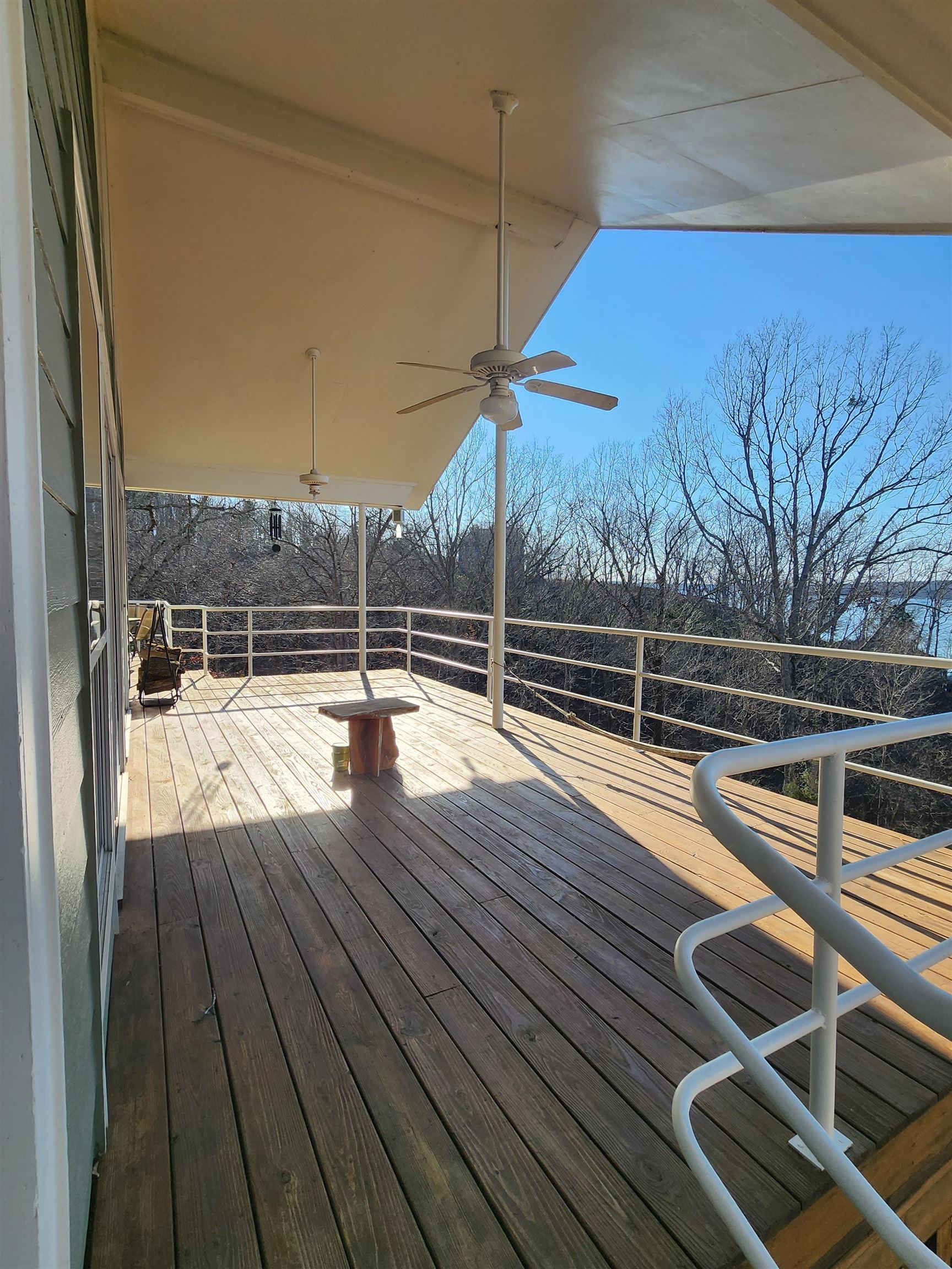 71 Chickasaw Trace Cherokee, AL 35616 - Photo 5 of 19 Expansive wood-finish deck with a full overhead covering, multiple ceiling fans, and white railing