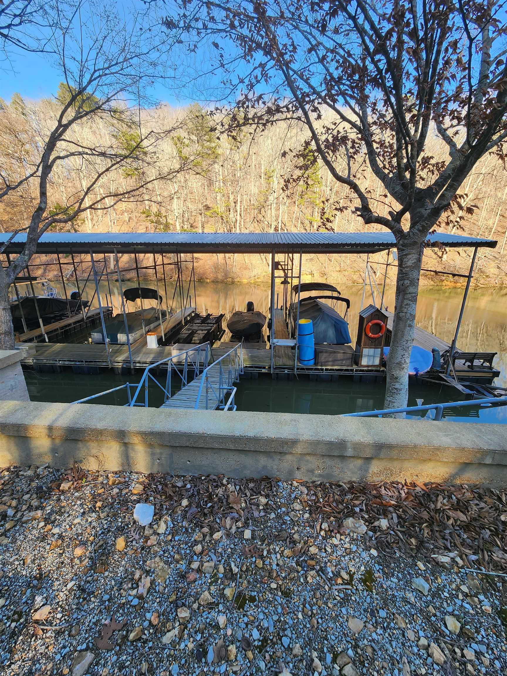 71 Chickasaw Trace Cherokee, AL 35616 - Photo 6 of 19 Private boat dock featuring a metal roof structure, multiple boat slips, and a metal gangway