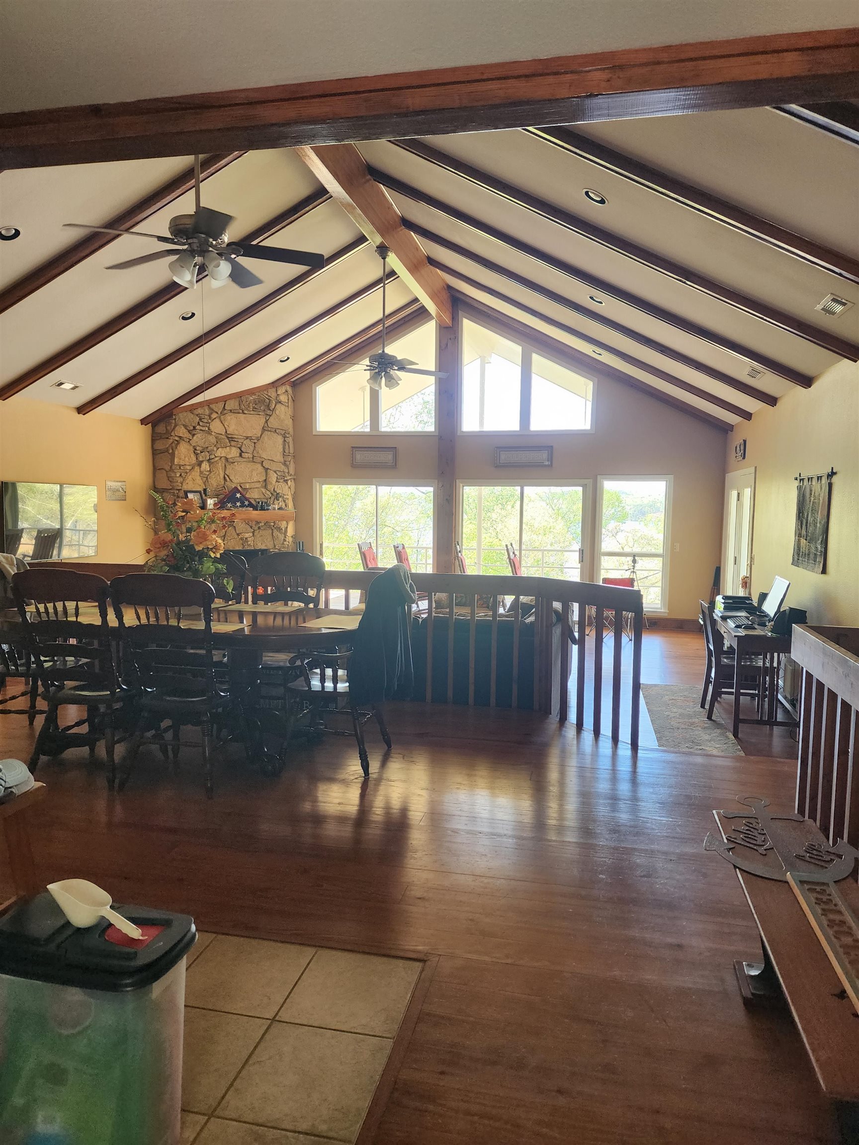 71 Chickasaw Trace Cherokee, AL 35616 - Photo 7 of 19 Vaulted ceiling with exposed wood beams, stone fireplace, wood-finish flooring, recessed lighting, and expansive windows