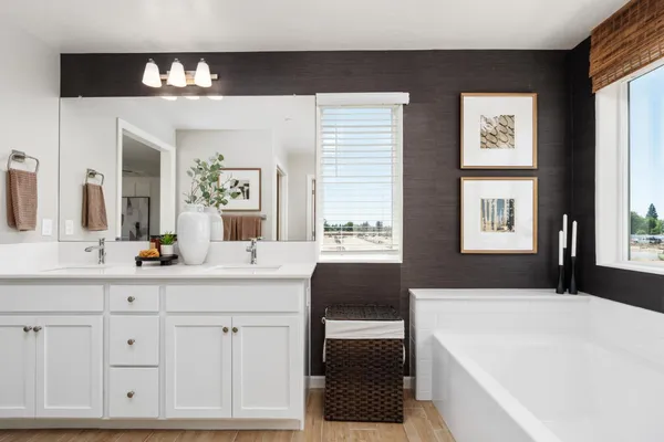 a spacious bathroom with a bathtub a sink and a large mirror