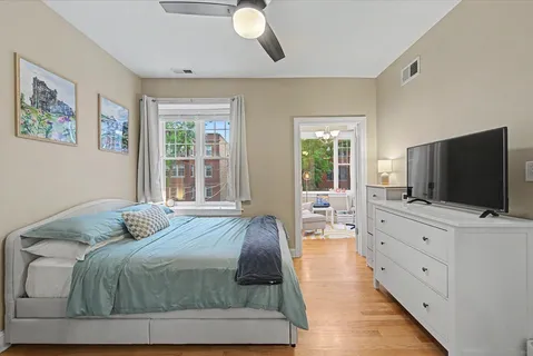 a bedroom with a large bed and flat tv screen on dresser