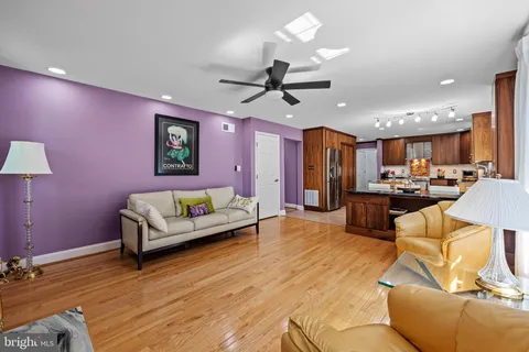 a living room with furniture kitchen view and a large window