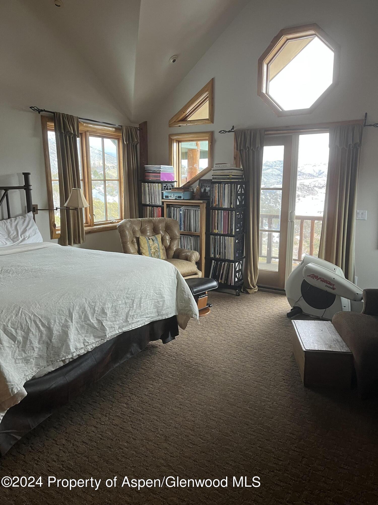 234 Light Hill Road Snowmass, CO 81654 - Photo 9 of 22 a bedroom with a large bed closet and two windows