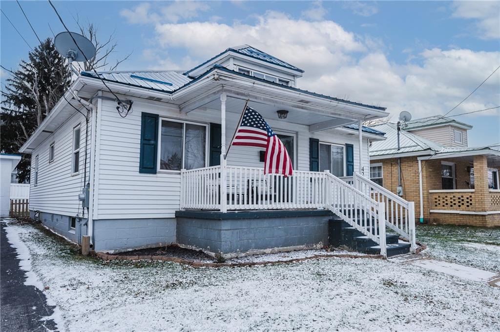 a view of a house with a small yard and a wooden deck