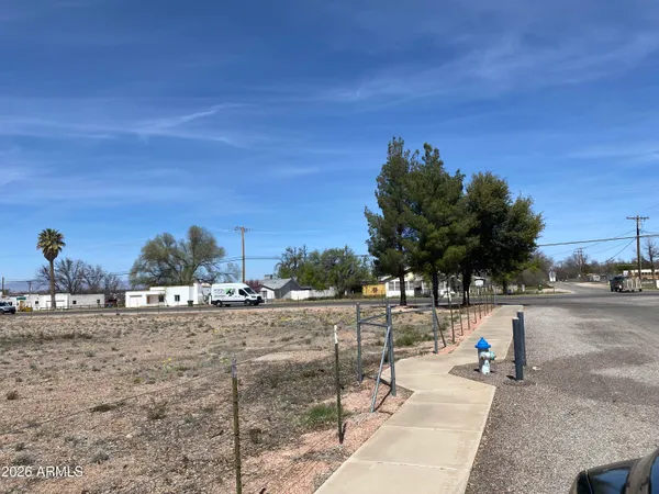 a view of dirt road with a building in the background