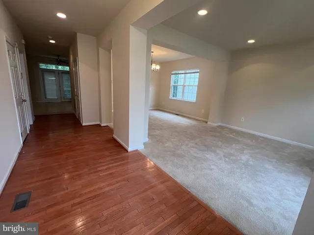 a view of a hallway with wooden floor and closet