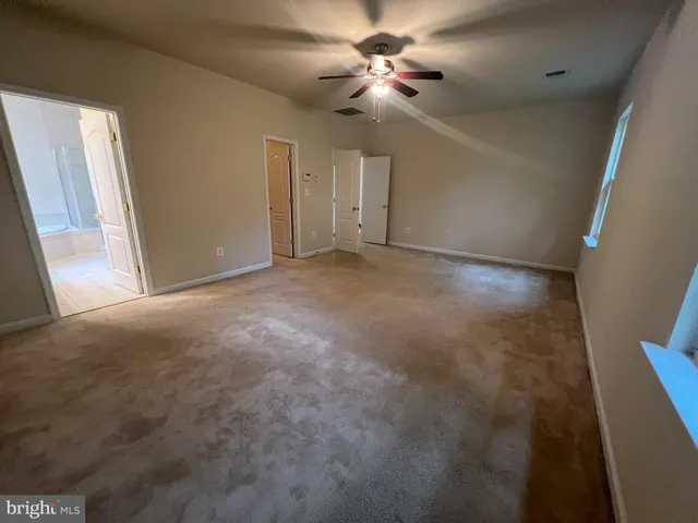 a view of a big room with chandelier fan and windows