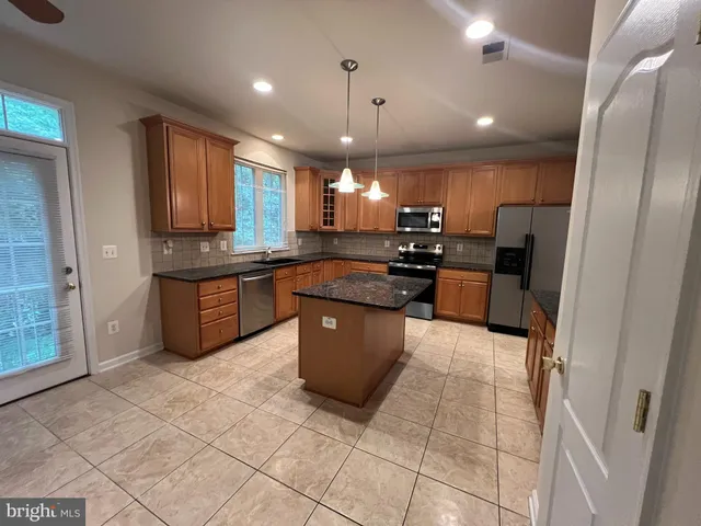 a large kitchen with a large counter top appliances and cabinets