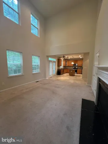 a view of an empty room with a fireplace and a window