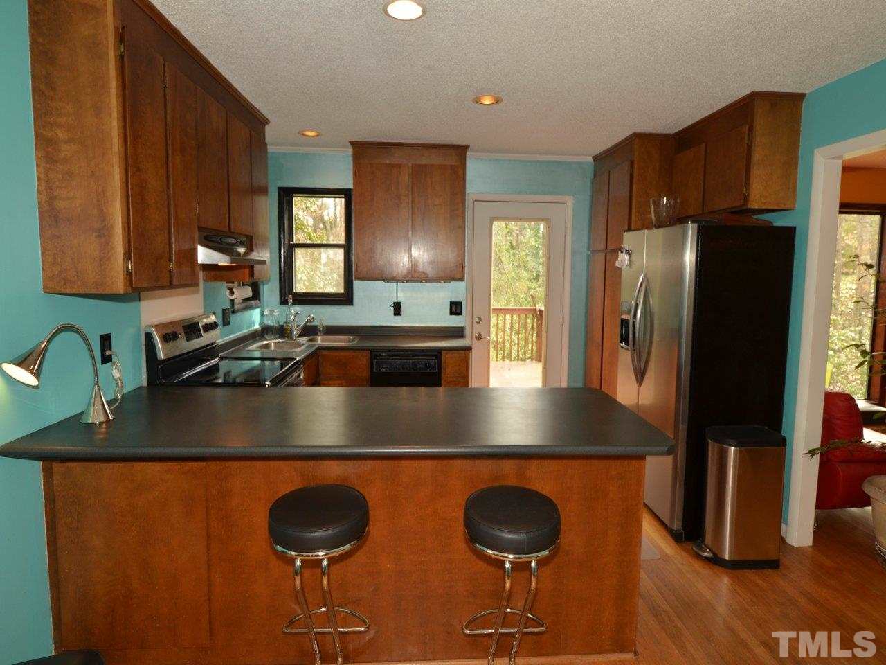 2812 Old Orchard Road Raleigh, NC 27607 - Photo 10 of 25 a kitchen with stainless steel appliances granite countertop a sink refrigerator and a stove