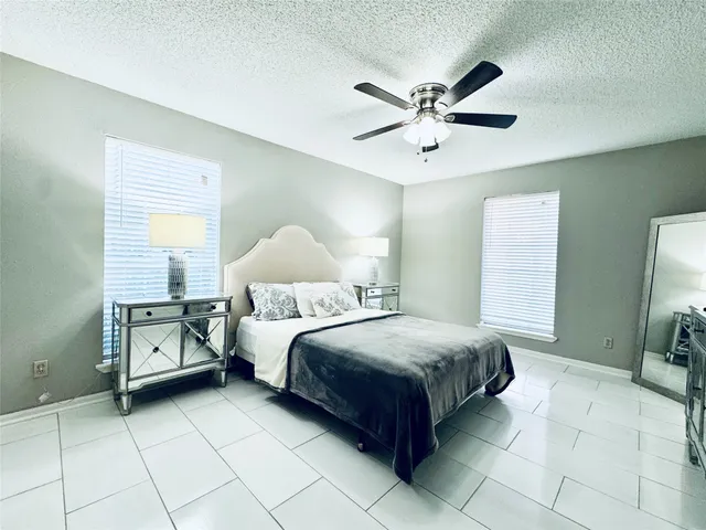 a spacious bedroom with a bed and a chandelier