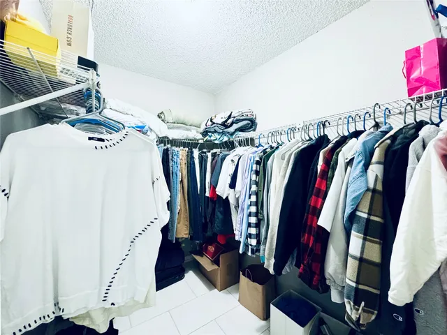 a view of walk in closet with clothes