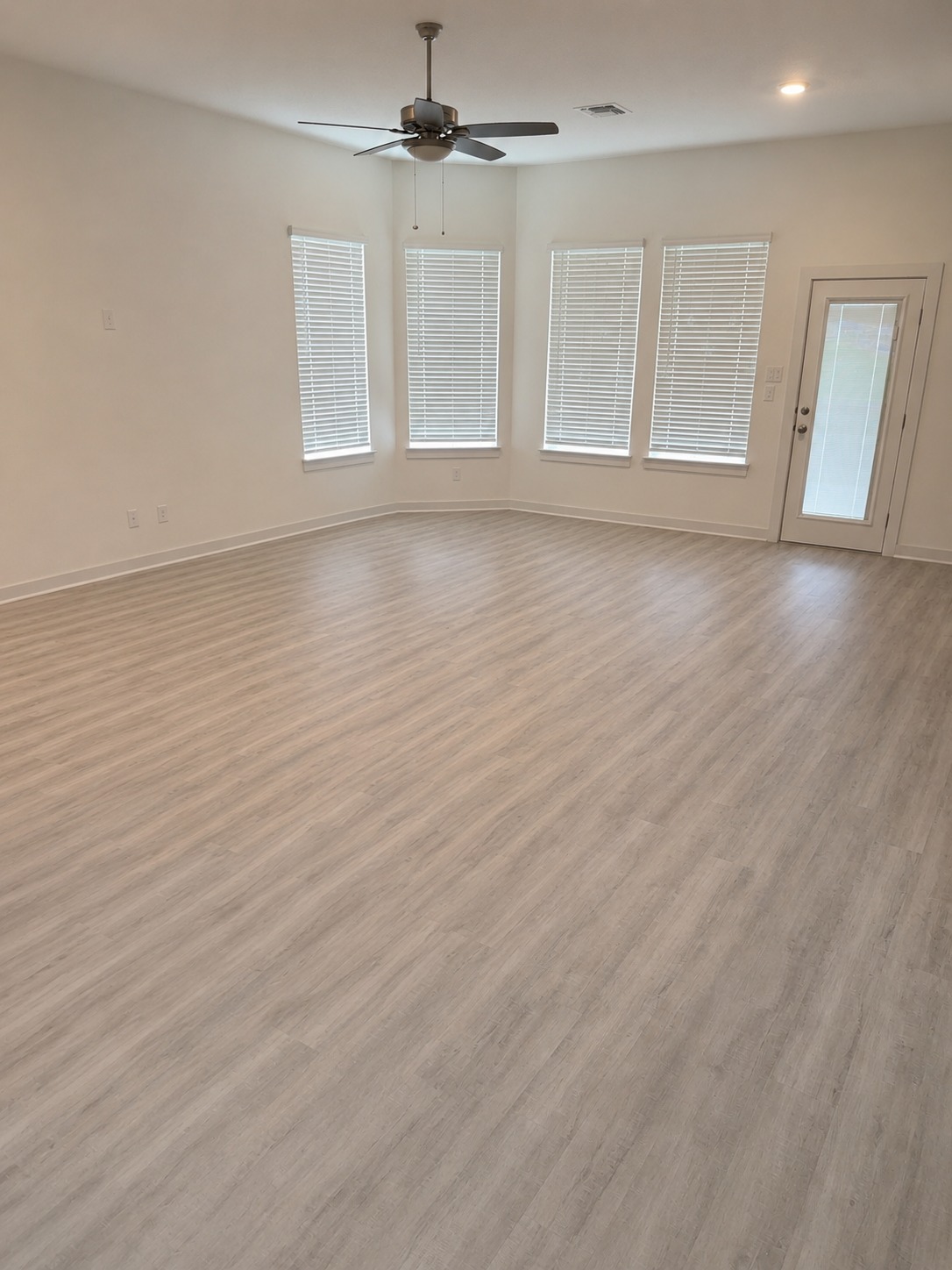 1213 Bryson Rdg Trail Leander, TX 78641 - Photo 5 of 16 Well-lit living area with tall windows, a convenient outdoor access, and overhead ceiling fan.
