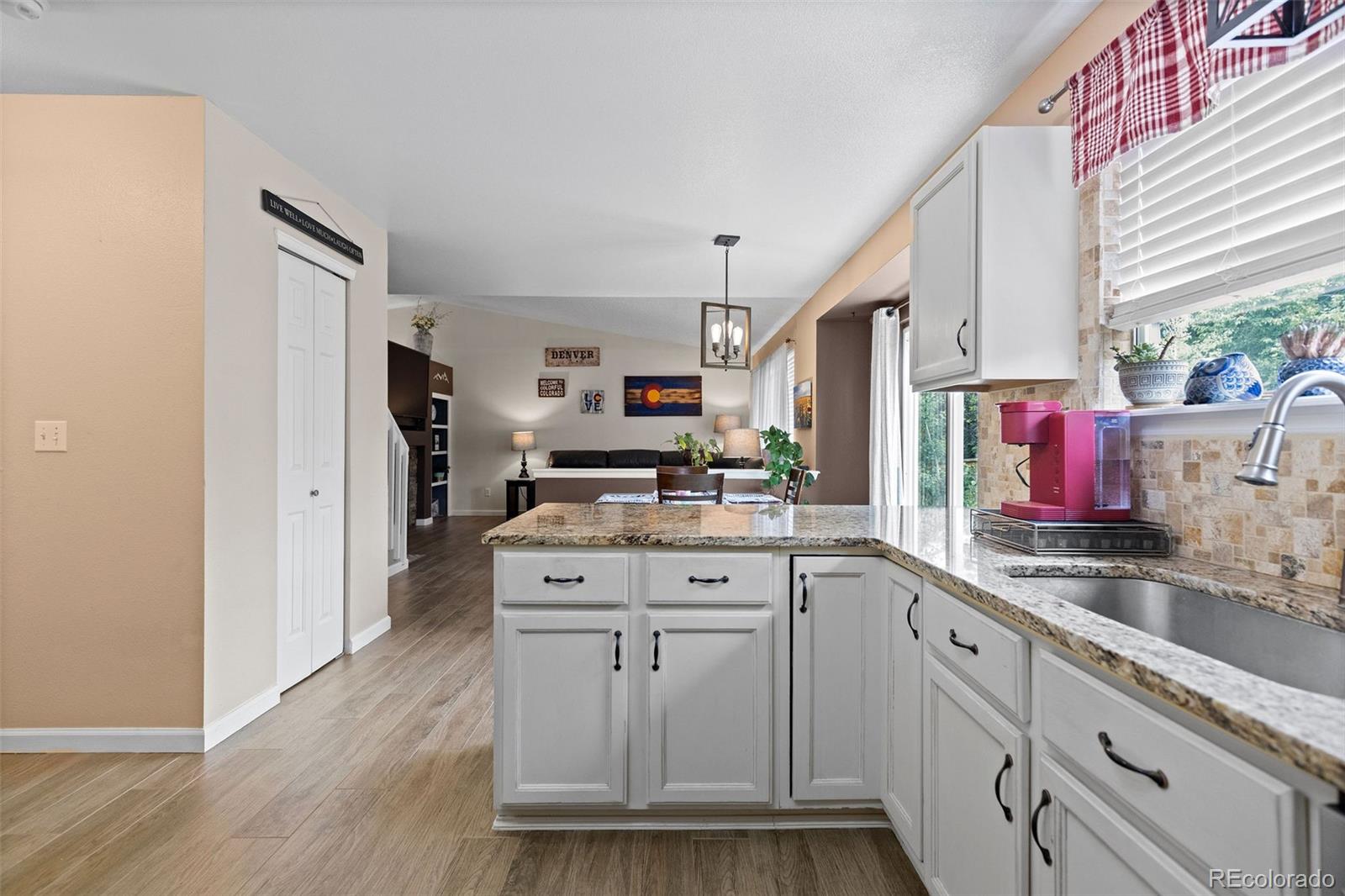 10565 Hyacinth Place Highlands Ranch, CO 80129 - Photo 14 of 33 a kitchen with white cabinets and sink