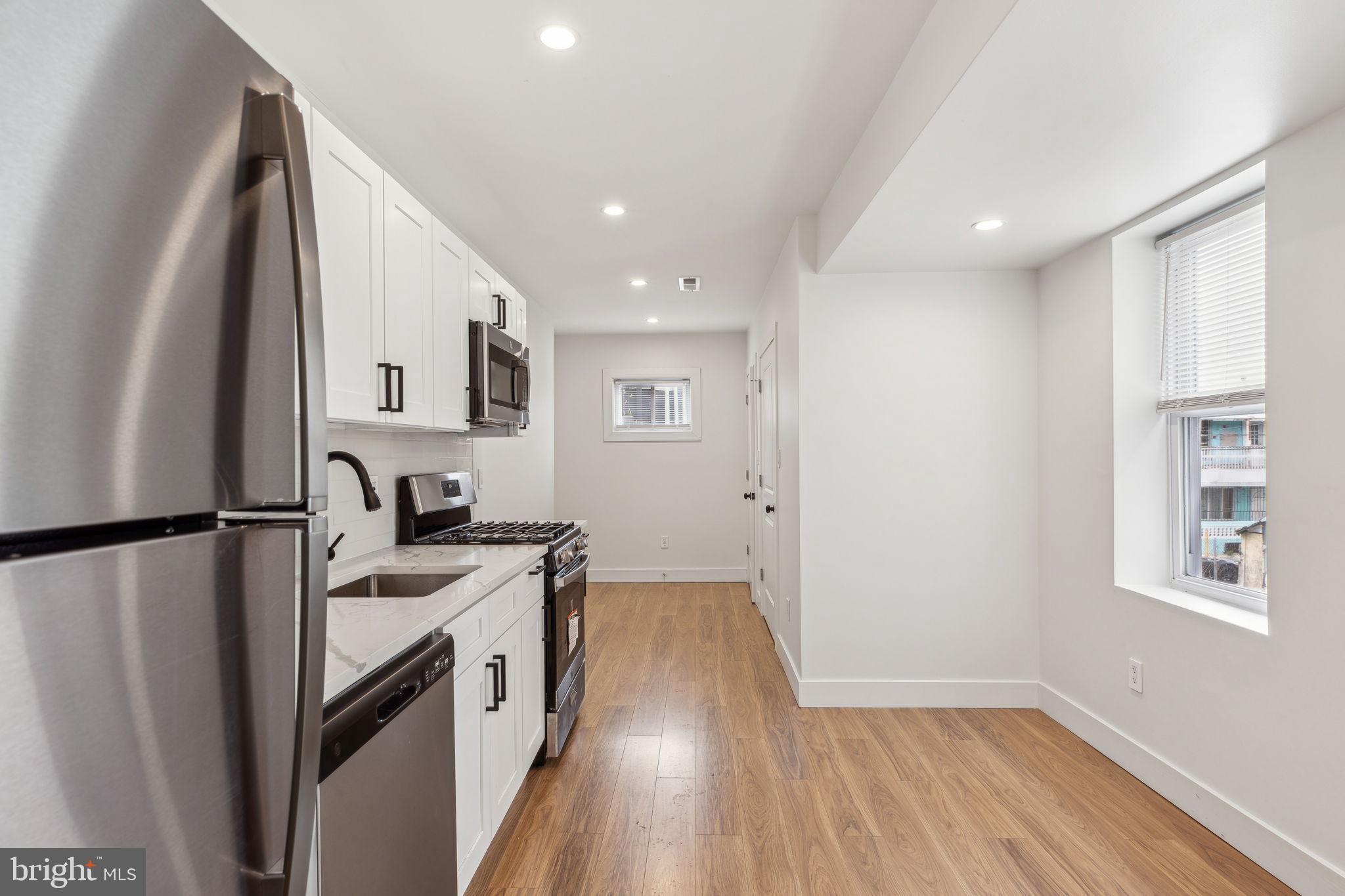 2014 North 3rd Street, Unit B Philadelphia, PA 19122 - Photo 4 of 19 a kitchen with a refrigerator a sink and wooden floor