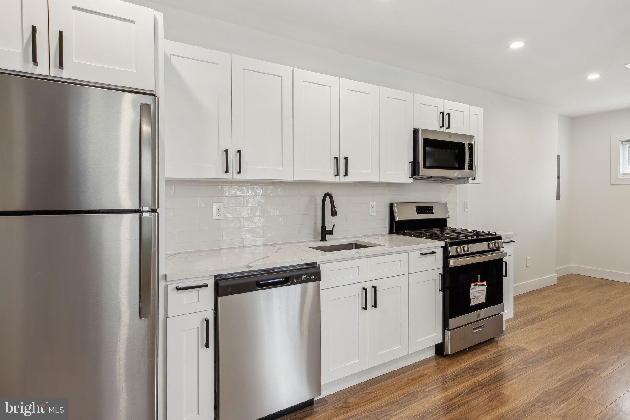 2014 North 3rd Street, Unit B Philadelphia, PA 19122 - Photo 5 of 19 a kitchen with stainless steel appliances a refrigerator stove and microwave