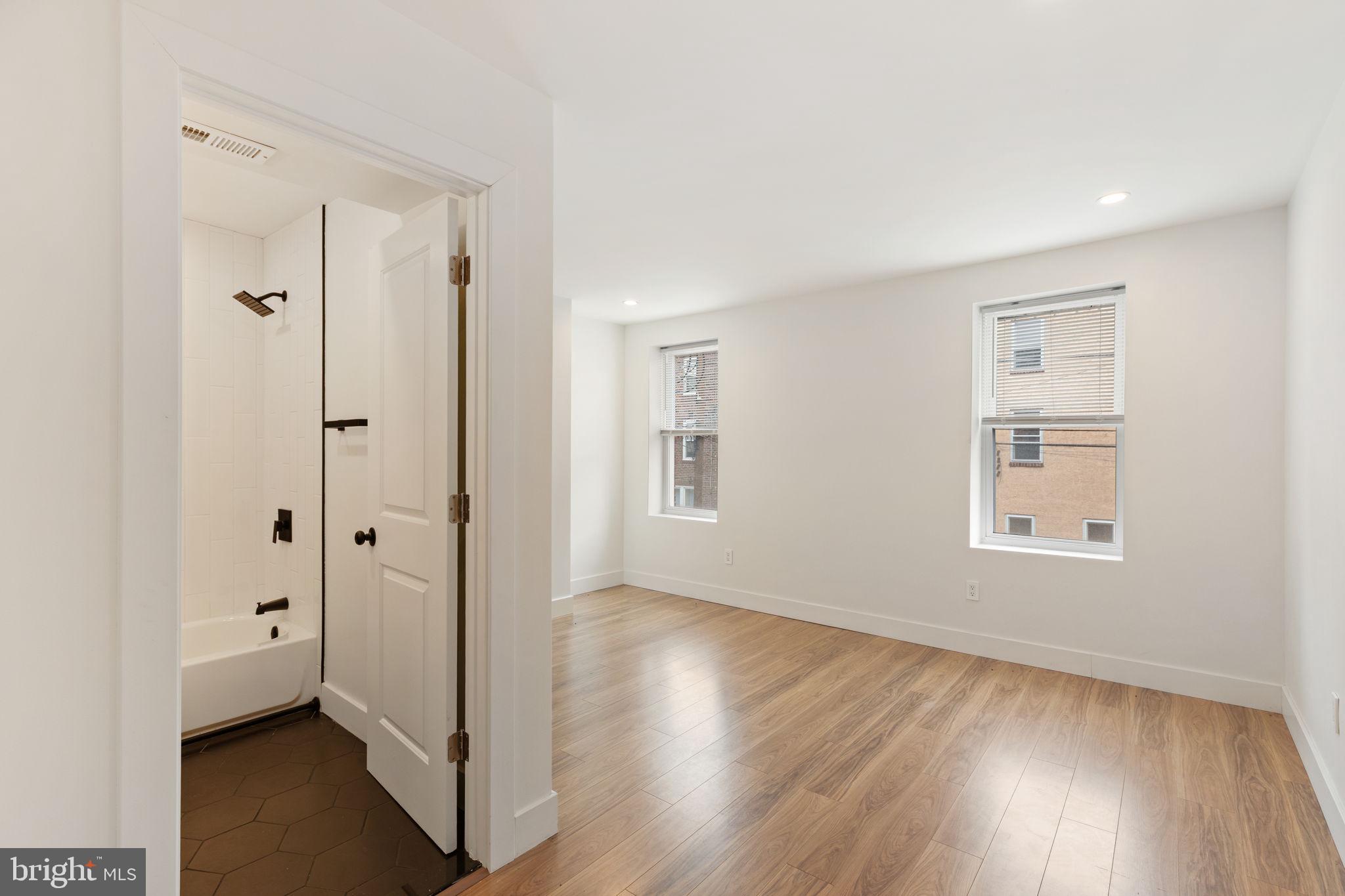 2014 North 3rd Street, Unit B Philadelphia, PA 19122 - Photo 8 of 19 an empty room with wooden floor and windows