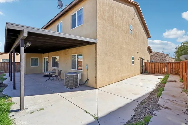 a view of a patio with table and chairs potted plants with wooden fence
