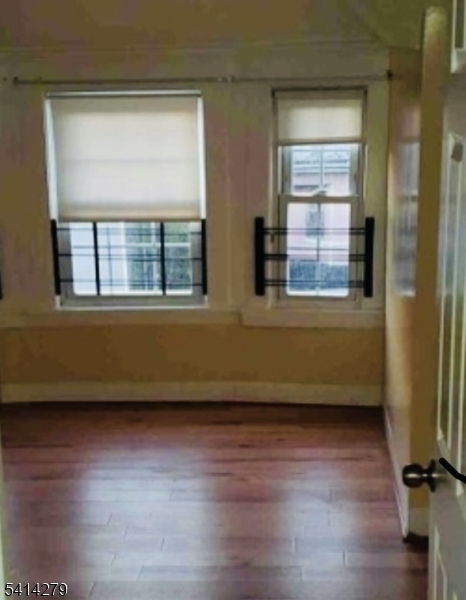 918 South 17th Street Newark, NJ 07108 - Photo 2 of 6 an empty room with wooden floor and windows