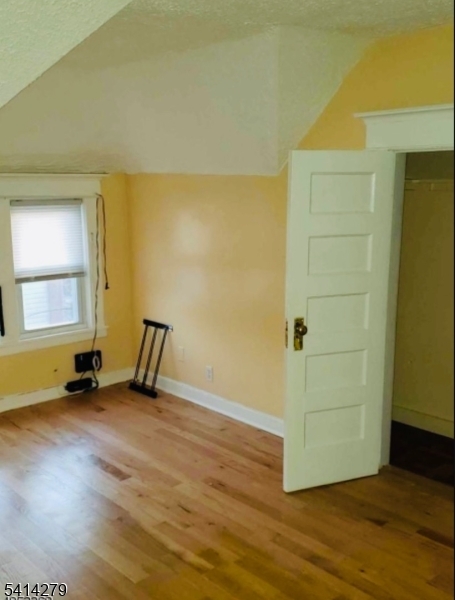 918 South 17th Street Newark, NJ 07108 - Photo 4 of 6 an empty room with wooden floor and windows