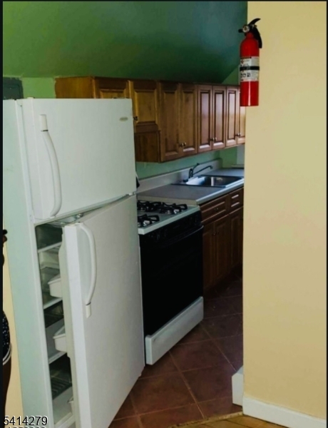 918 South 17th Street Newark, NJ 07108 - Photo 6 of 6 a kitchen with a stove and a refrigerator