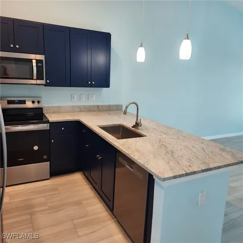 a kitchen with a sink and wooden floor