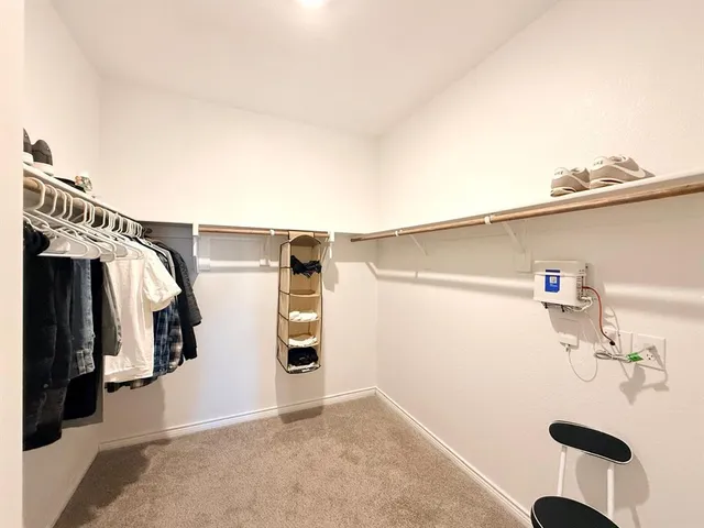 a view of walk in closet with clothes and shoes