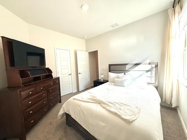 a bedroom with a bed and a flat screen tv