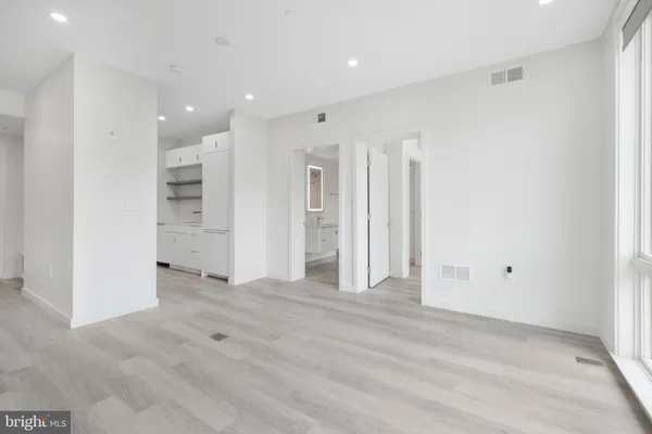 a view of an empty room with wooden floor