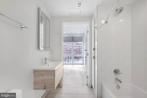a bathroom with a bathtub shower sink and mirror